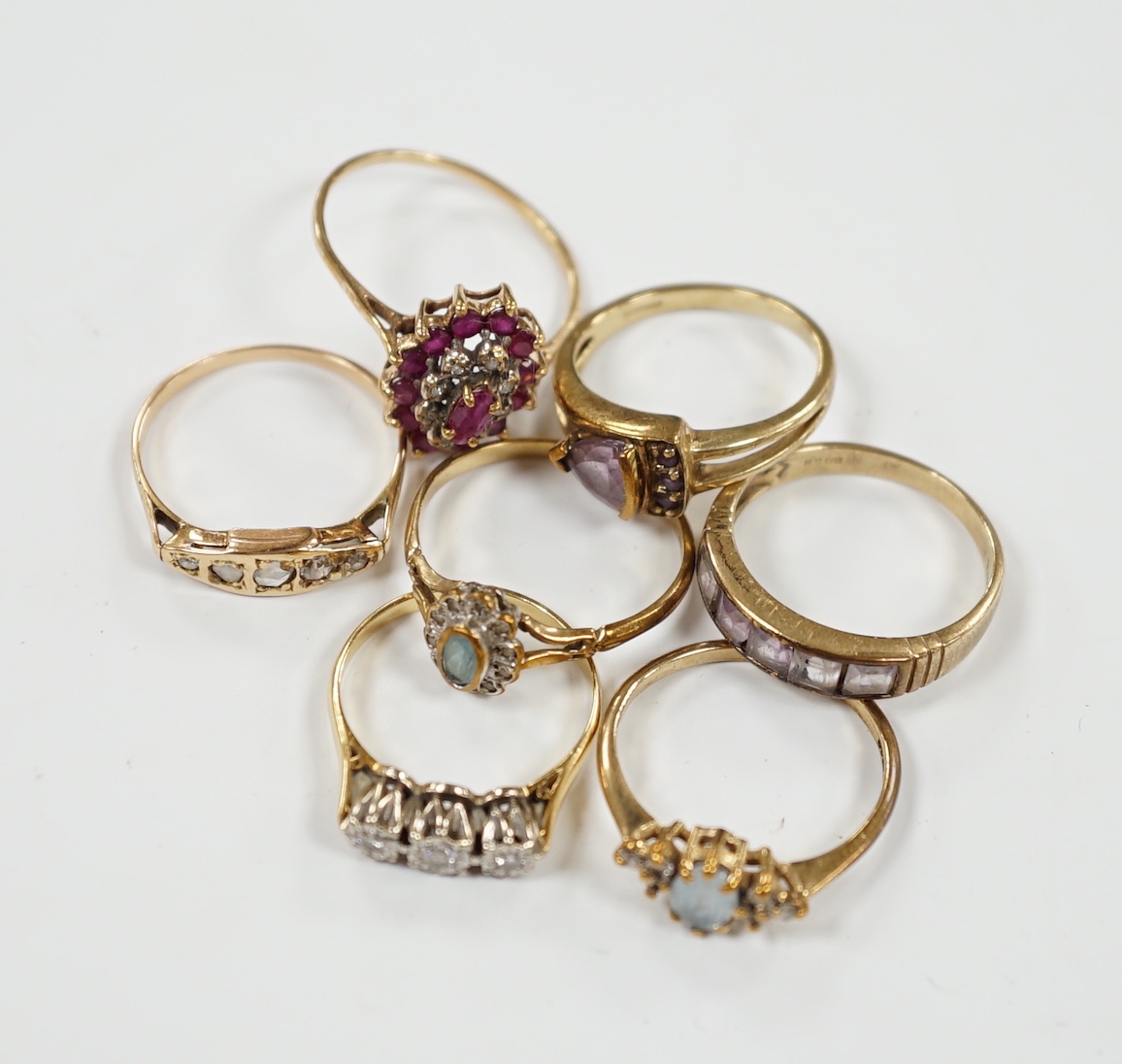 Seven assorted mainly modern 9ct gold and gem set dress rings, including three stone diamond and five stone diamond, gross weight 15.7 grams.